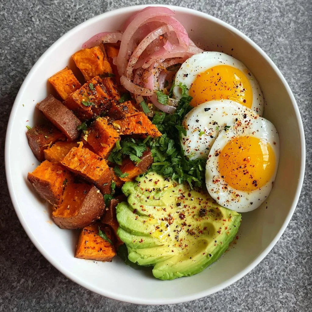 Delicious sweet potato breakfast bowl topped with fresh ingredients and herbs.