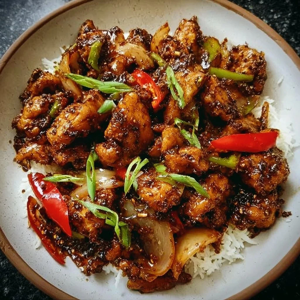 Delicious Black Pepper Chicken served with vegetables on a plate.