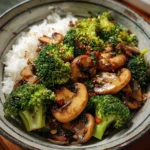 Vegan broccoli mushroom stir fry served in a colorful bowl with fresh vegetables