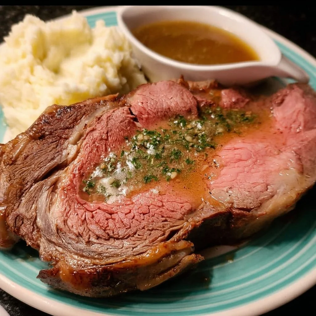 Sous vide prime rib roast with au jus and herb butter on a serving platter