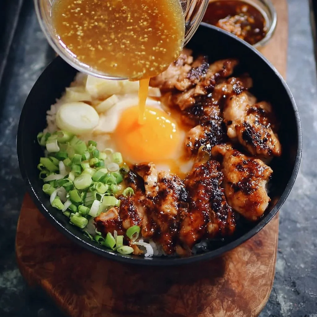 Japanese inspired chicken and egg rice bowl topped with fresh herbs and spices